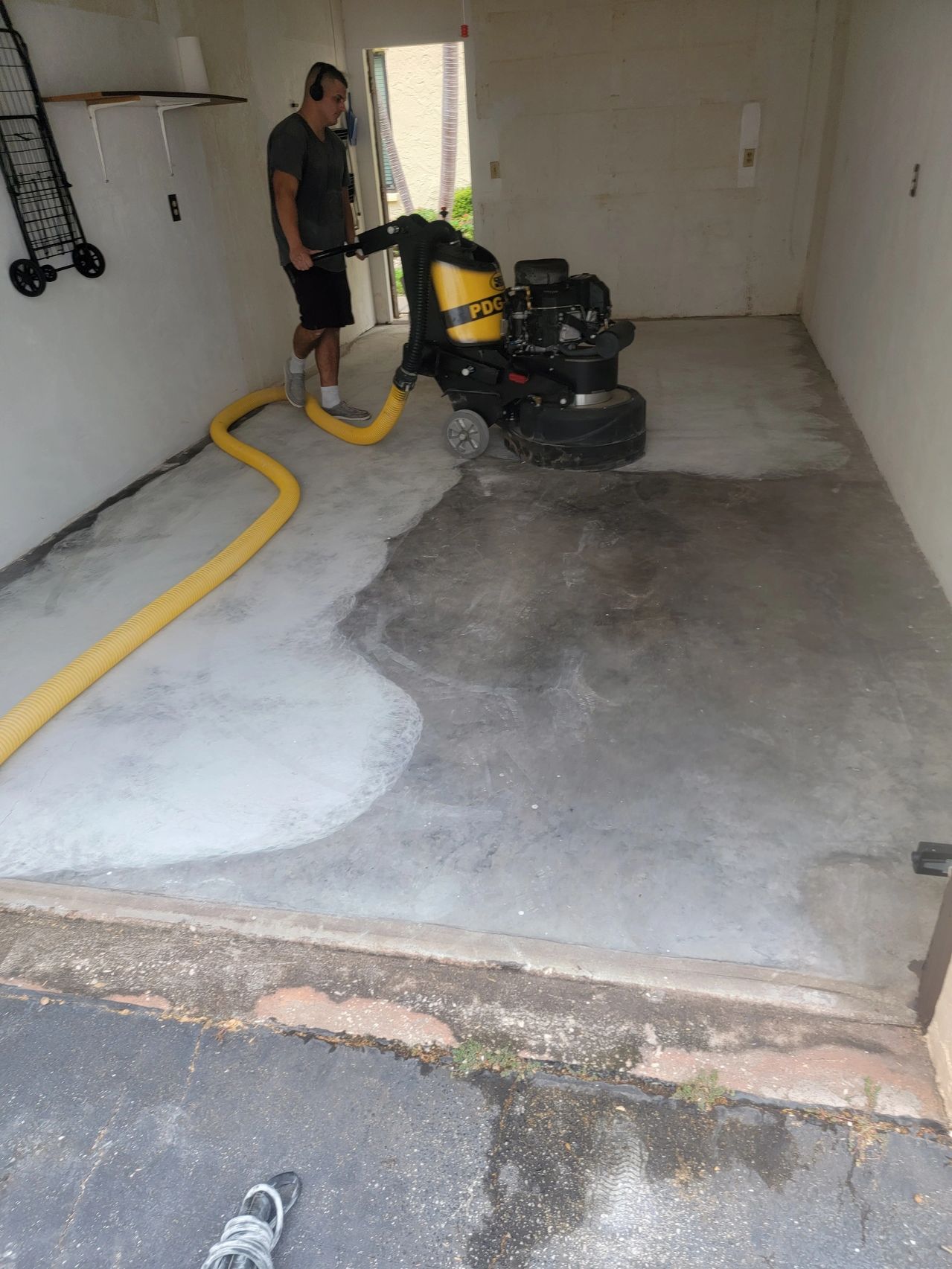 Man polishing concrete garage floor with grinder