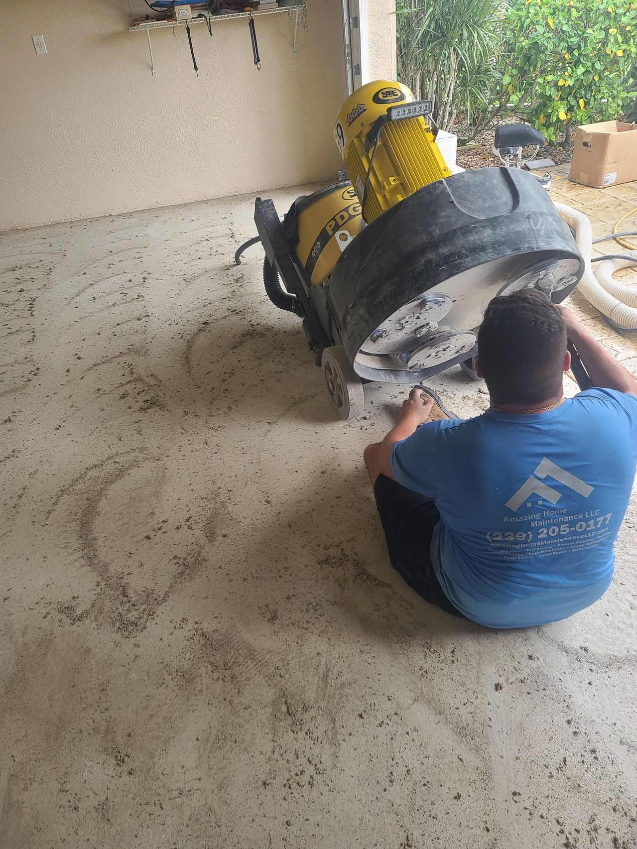 Worker operating concrete floor grinder