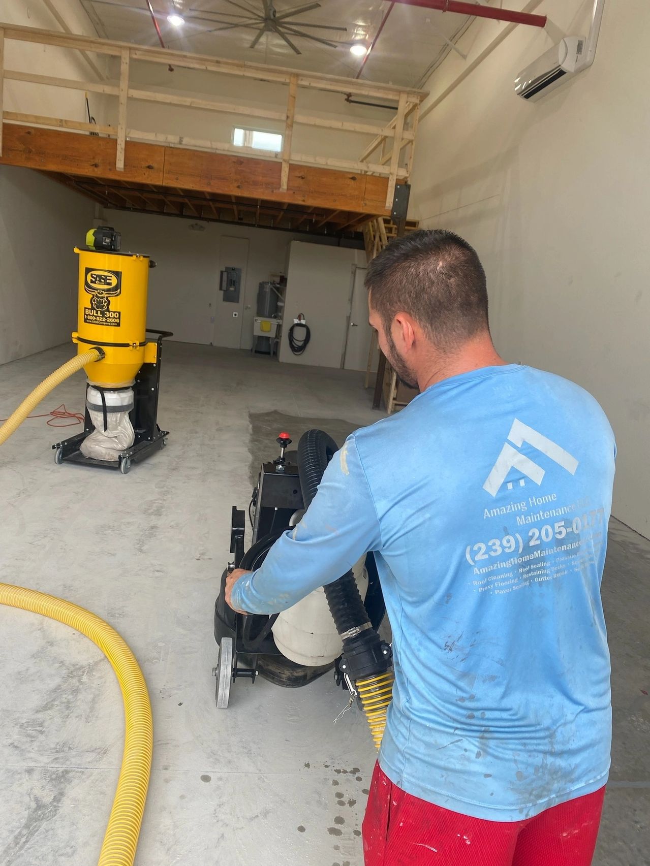 Worker operating floor grinder and dust extractor