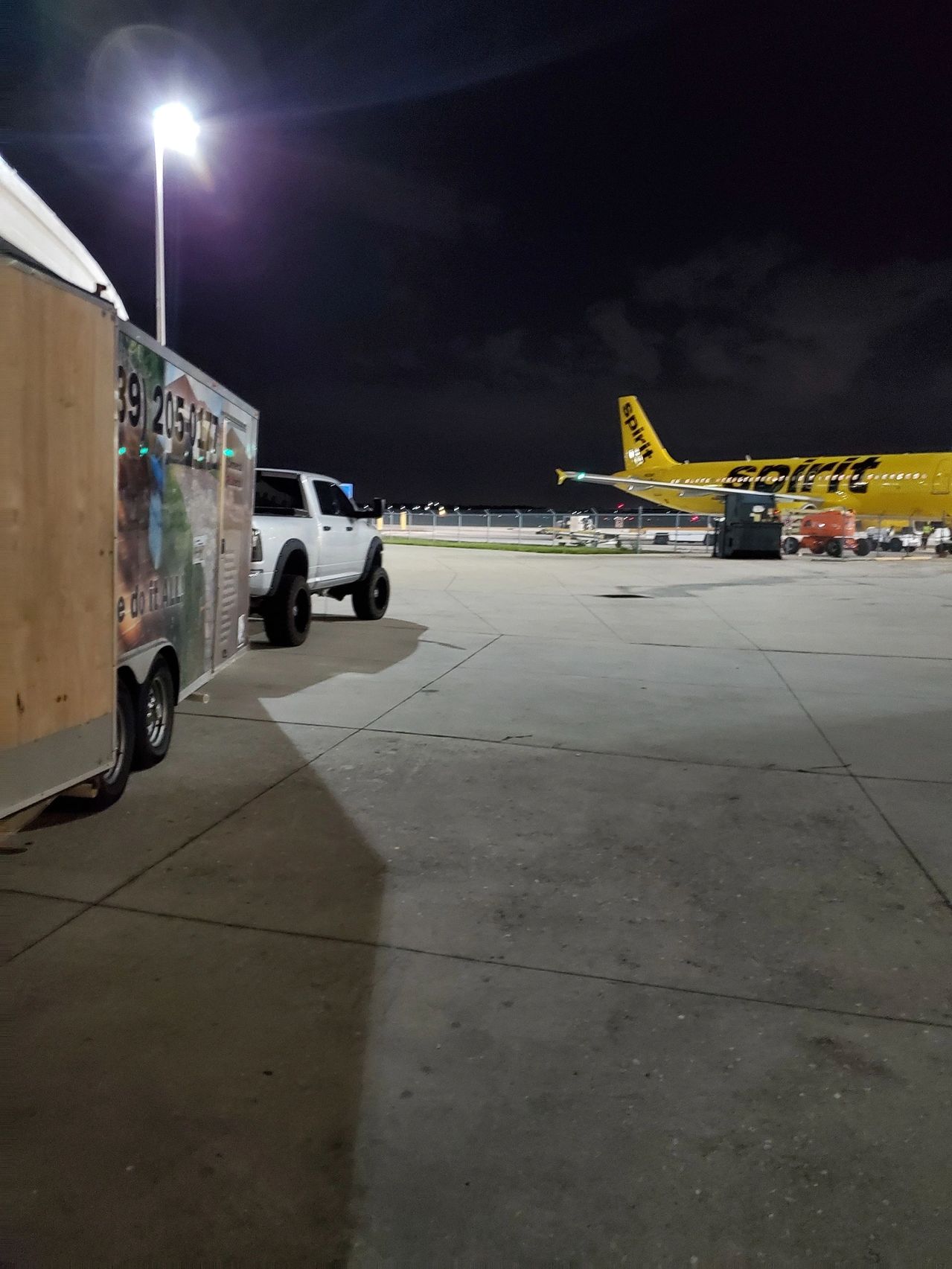 Night airport tarmac with yellow Spirit plane