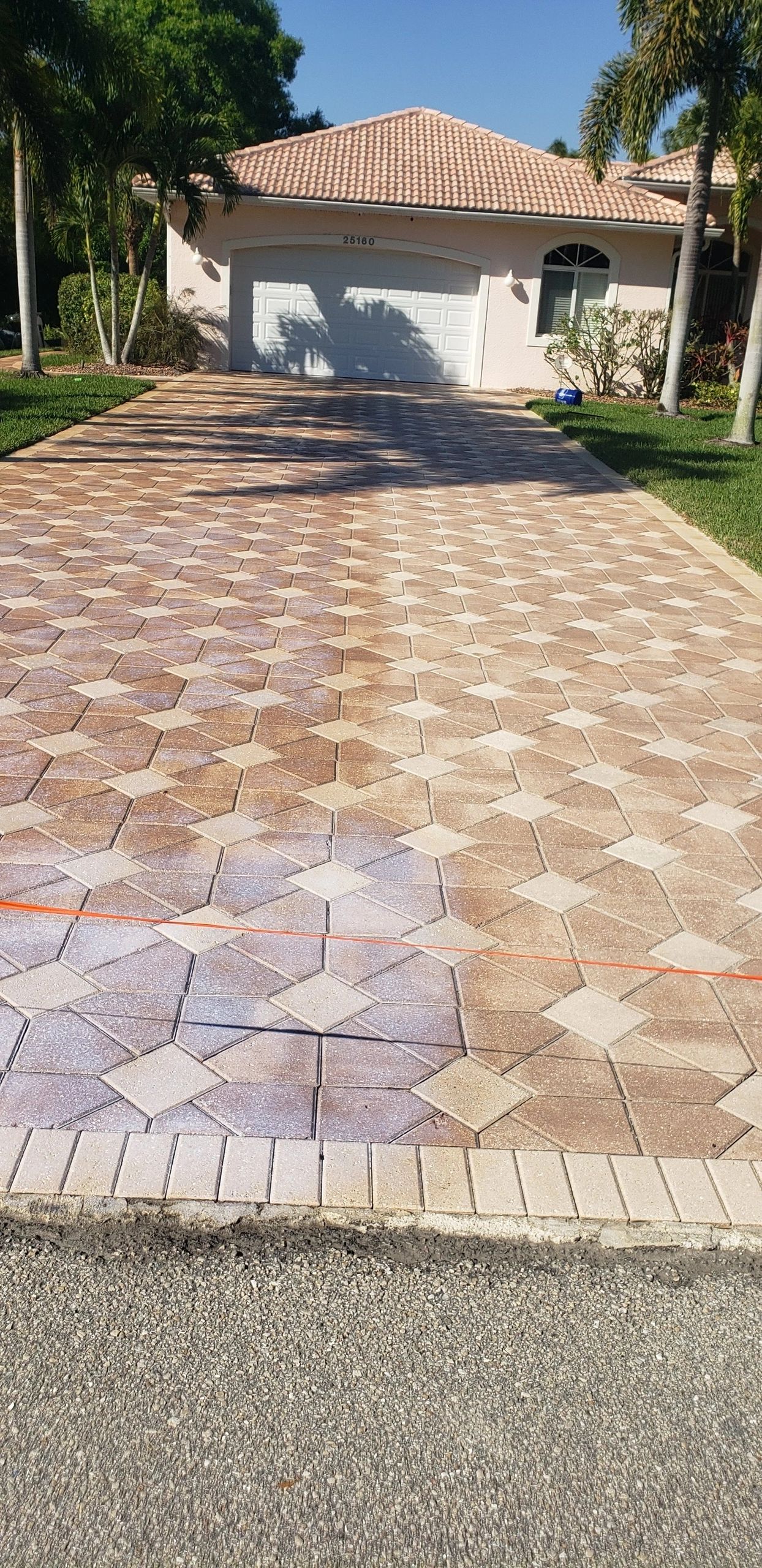 Patterned paver driveway leading to garage