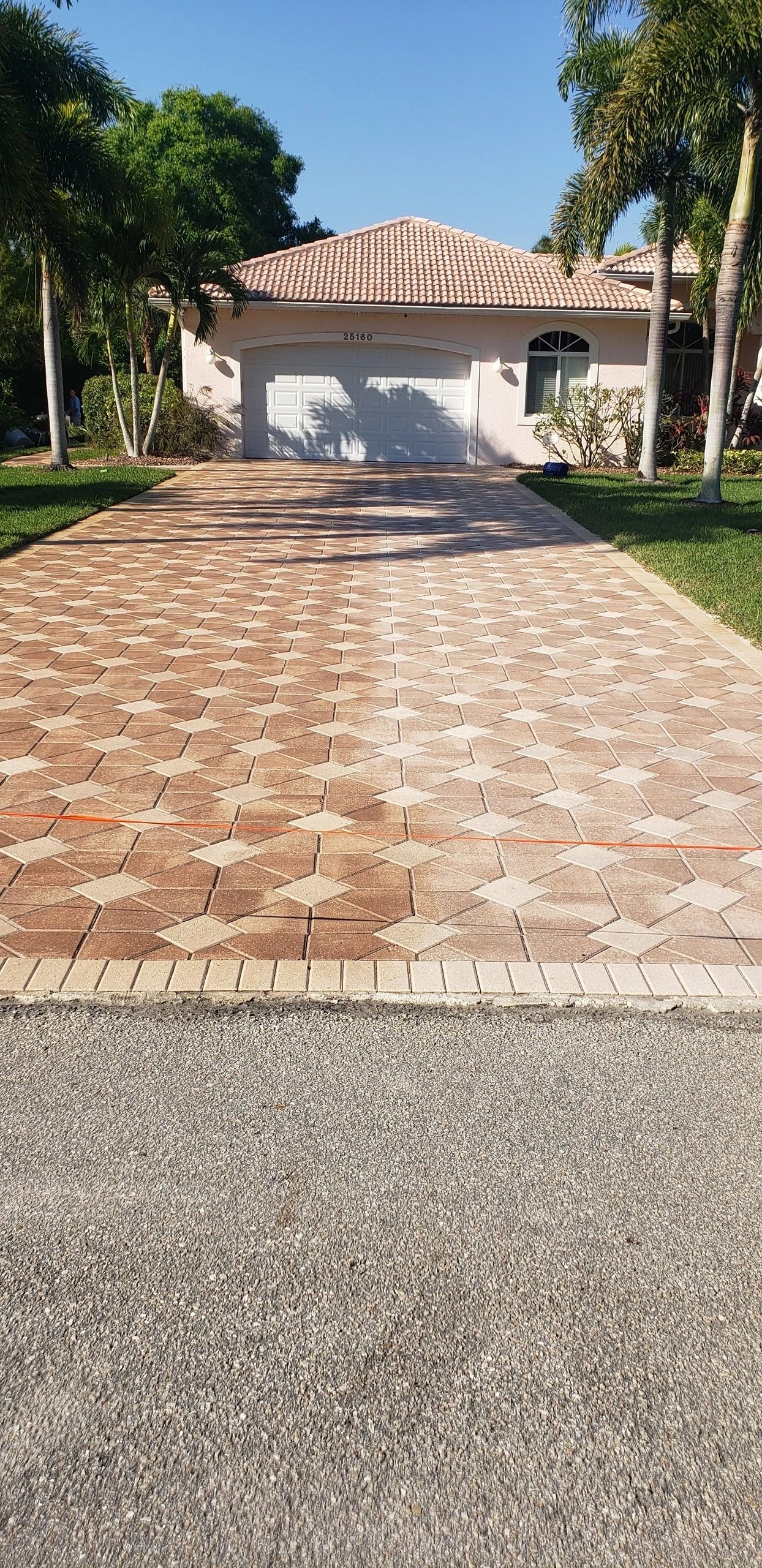 Paver driveway leading to house with garage
