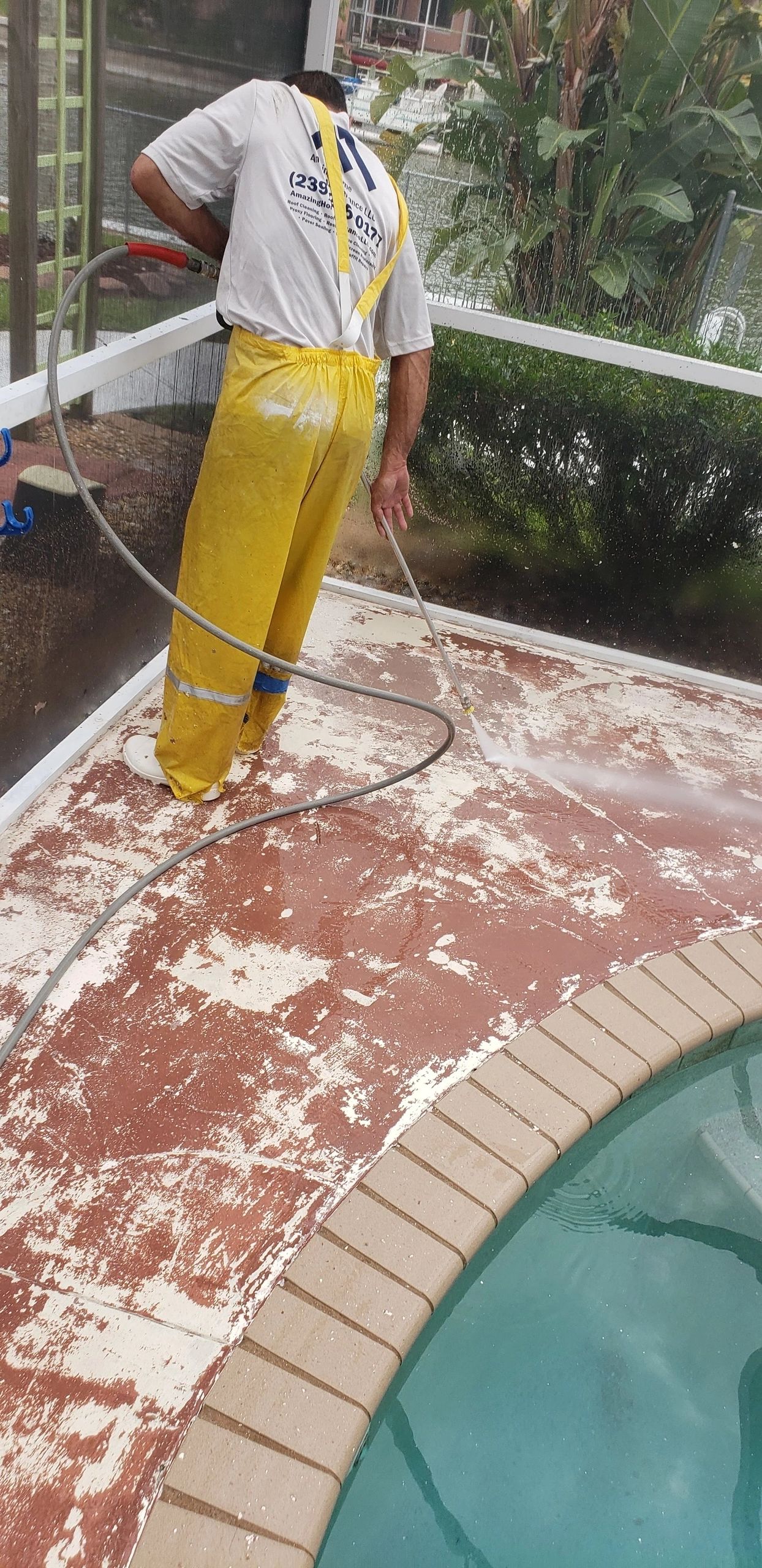 Worker pressure washing pool deck
