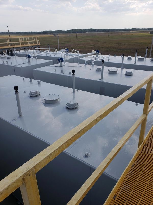 Close-up of clean gray industrial fuel storage tanks at an airport tank farm