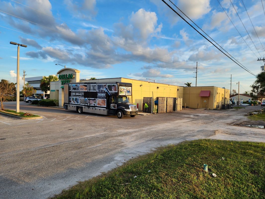 AHCM service truck parked outside a Dollar Tree shopping plaza for commercial pressure washing