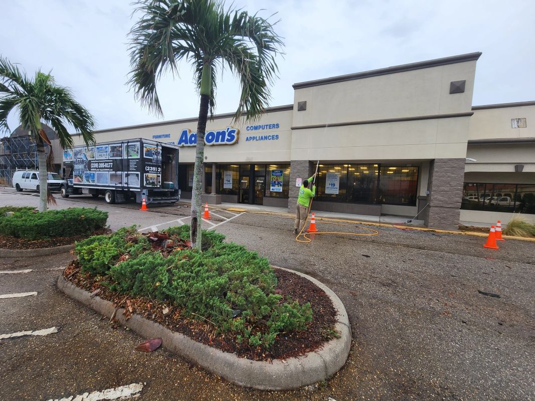 AHCM crew pressure washing the storefront and sidewalk at an Aaron's retail store