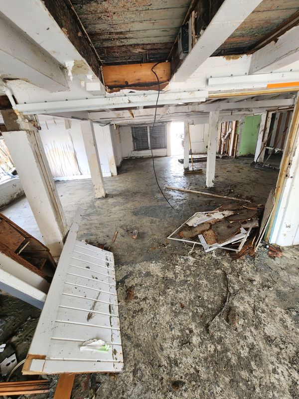 Interior of a gutted commercial building with storm damage awaiting industrial pressure washing cleanup
