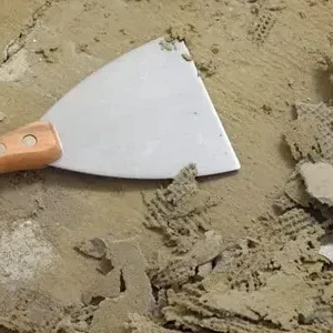 Putty knife and scraped plaster debris