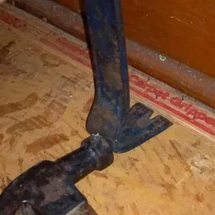 Pry bar and hammer on plywood subfloor