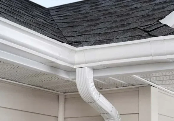 Corner roof with white gutter and downspout