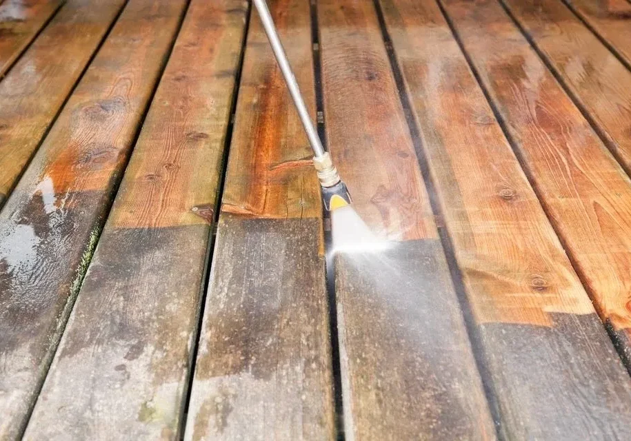 Pressure washing wooden deck removing grime