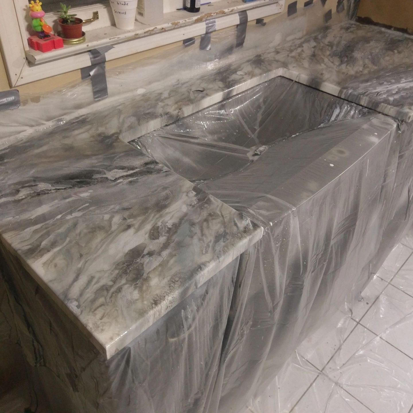 Marble-pattern countertop with sink covered in plastic