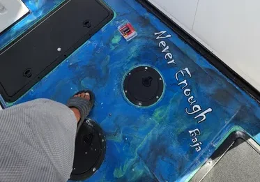Feet on blue boat deck, "Never Enough