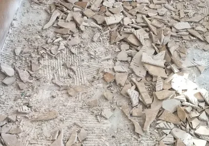 Scattered broken floor tiles and dust