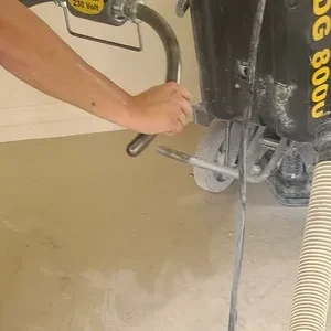 Worker operating concrete floor grinding machine