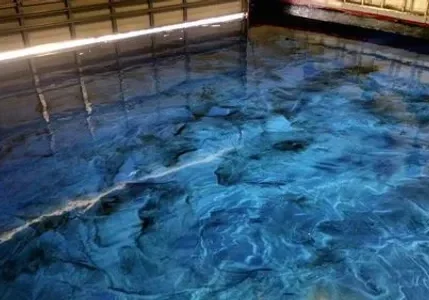Blue swirling water reflecting overhead lights