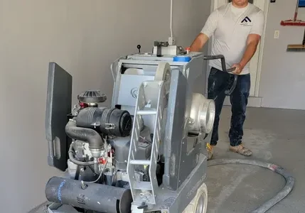 Worker operating large floor sanding machine