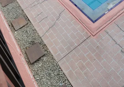 Cracked pool deck with gravel and stepping stones