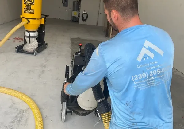 Worker operating concrete floor grinding machine